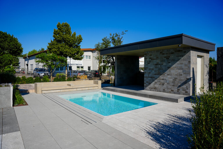 Pool-Ausstellung mit Naturstein & Poolhaus Große Poolausstellung mit Natursteinbelägen, Poolhaus und Blockstufen.